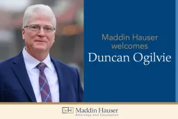 A man in a suit with the words Maddin Hauser welcomes Duncan Ogilvie