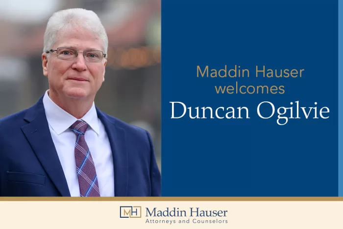 A man in a suit with the words Maddin Hauser welcomes Duncan Ogilvie